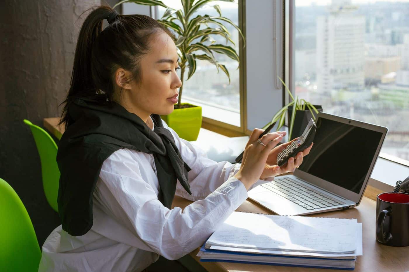 Gérante de PME calculant ses indicateurs de gestion au bureau